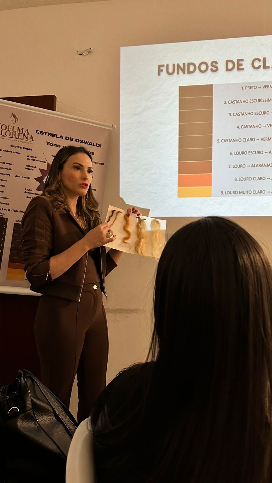 Joelma Lorena ensinando os fundos de clareamento com mechas na mão durante aula de colorimetria